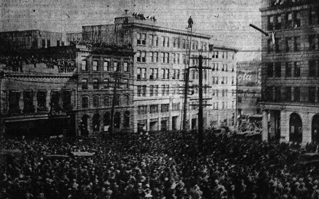 Ten thousand people watched the “Human Fly” clinging to the bare, sheer surface of the Vancouver World Building, winning his way by the sheer strength of his hands 340 feet above their heads, 1918.