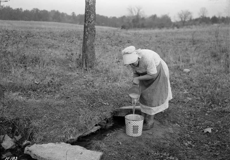 Mrs. Wallace dipping water from spring on farm near Norris townsite recently purchased by the TVA for experimental purposes, Tennessee, November 1933