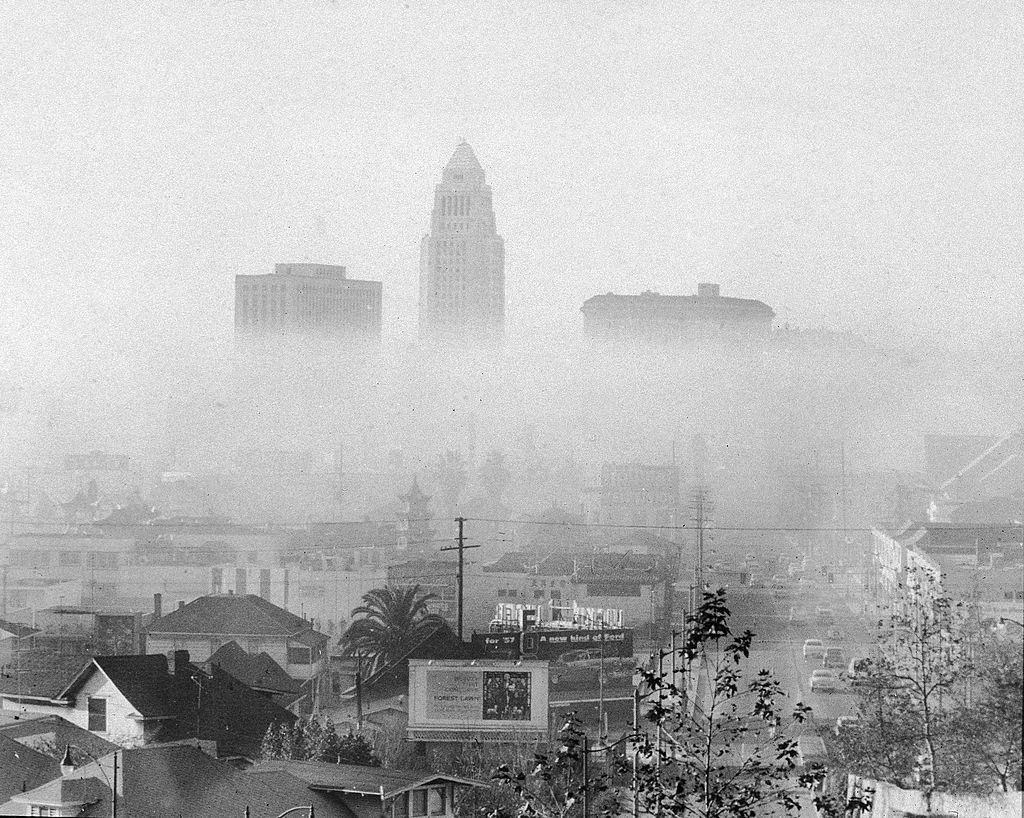 Skyline of downtown Los Angeles including the city hall (center) and the United States Courthouse (left), and Hall of Justice (right) shrouded and obscured by smog.