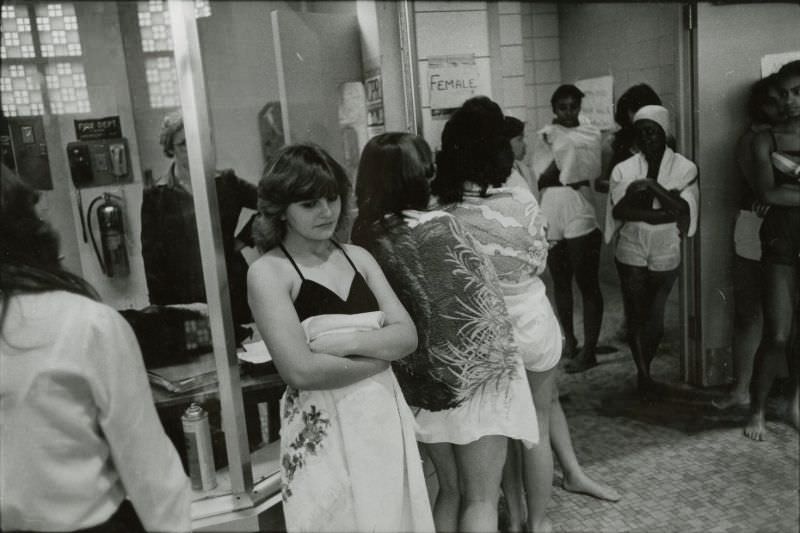Women in bathing suits wait outside a locker room