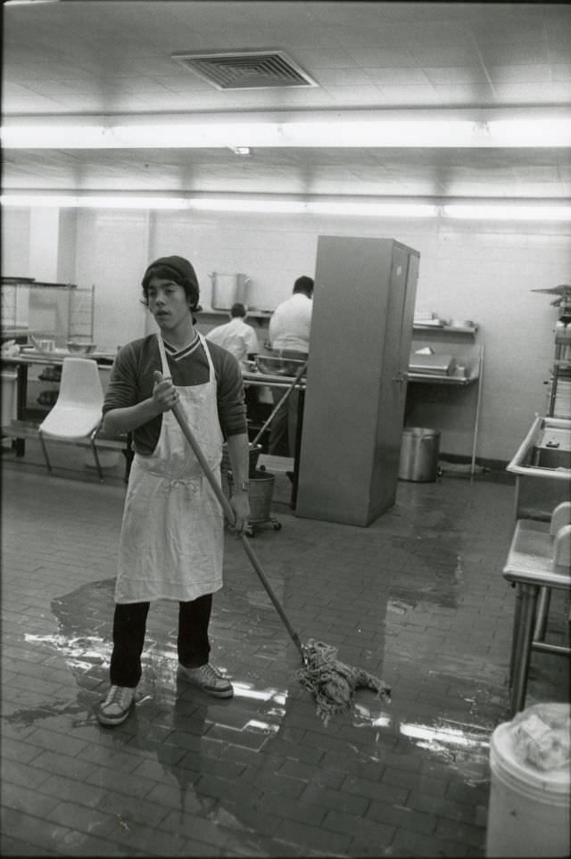 Student mopping cafeteria kitchen
