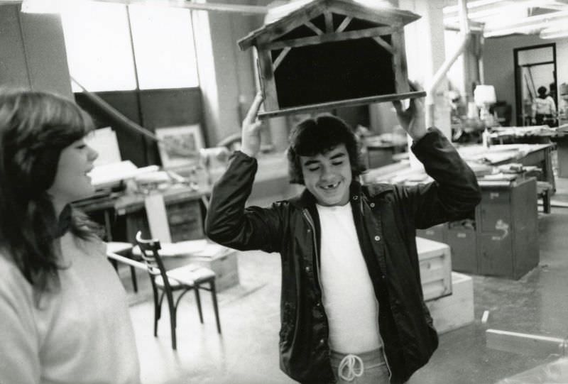 Boy holding a small wooden construction above his head