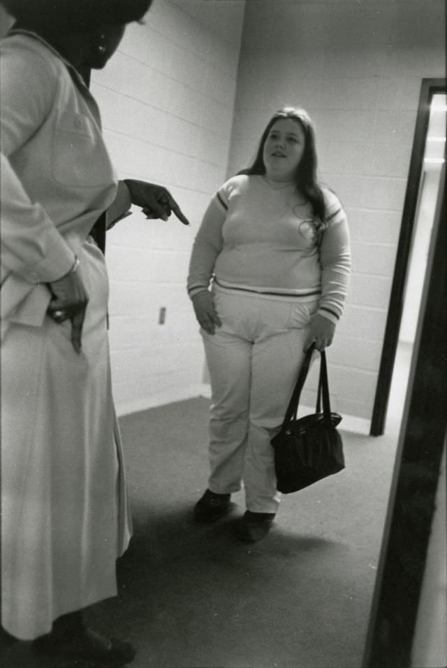 Teacher addressing a student in a hallway