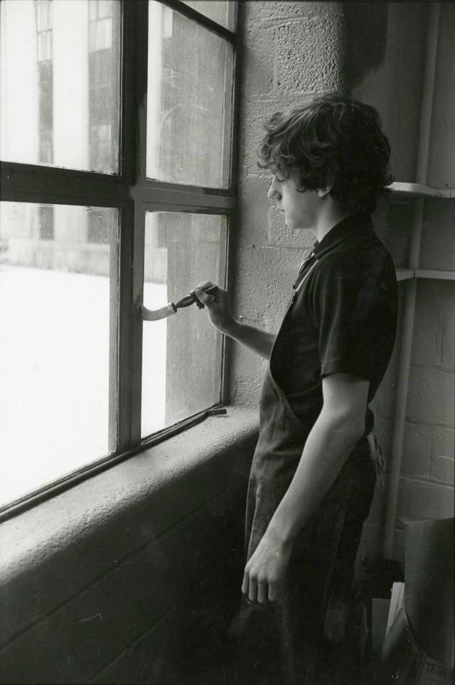 Boy painting a window frame