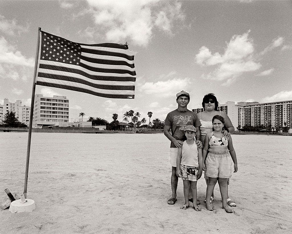 Hispanic family posing next to the American Flag on Miami Beach.