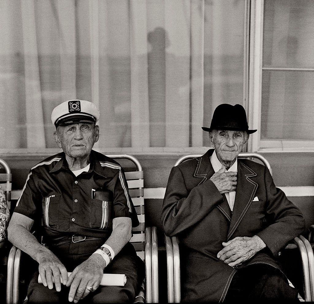 Elderly Jewish emigrates sitting out on the porch of run down Guest house and dilapidated Art Deco hotels.