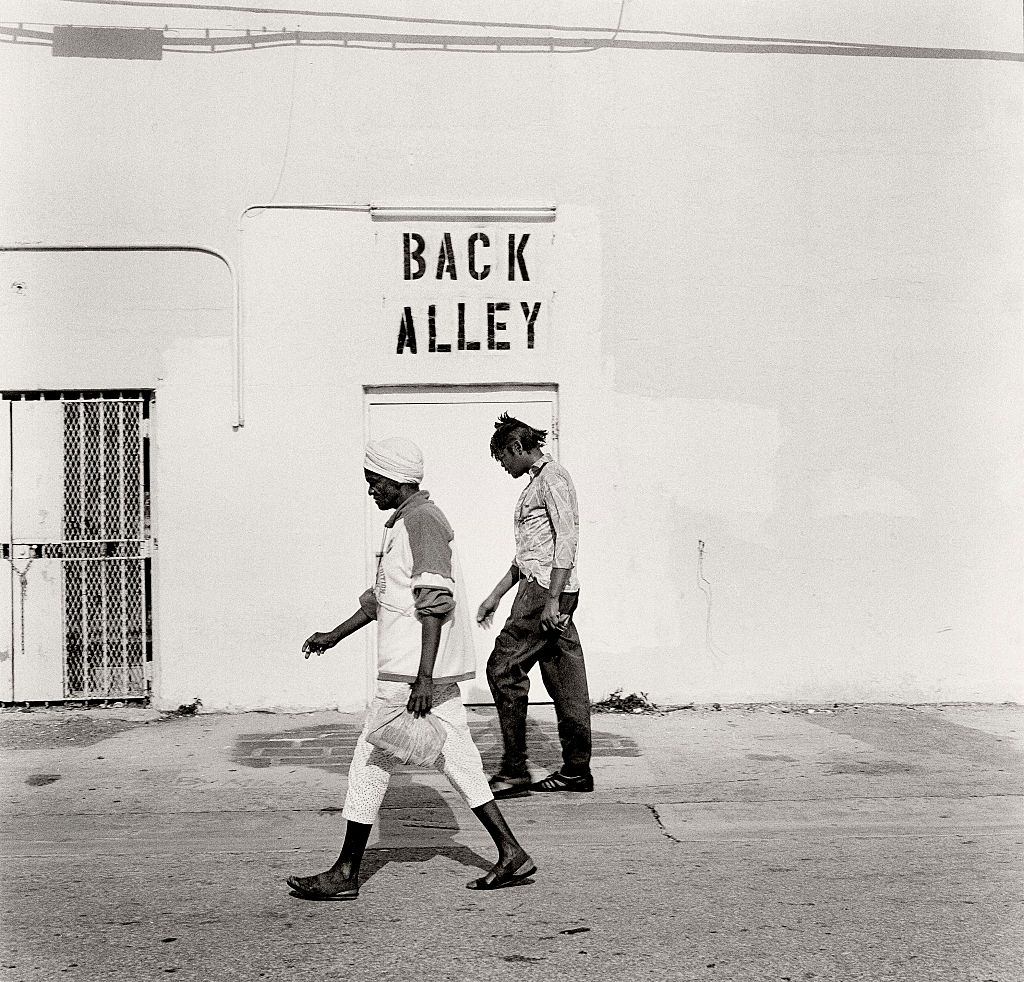 Alley running along Washington. Walk down the hidden Alleyways that run behind the Art Deco Hotels on Ocean Drive, South Beach and you will see a different world.