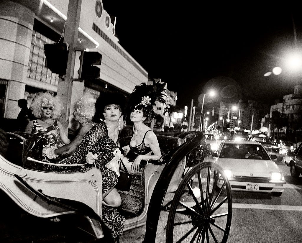 Drag queens arriving in a horse drawn carriage.
