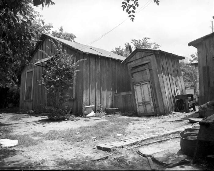 Unpainted house and outhouse behind houses in 400 block N. San Saba Street, San Antonio, Texas, 1968