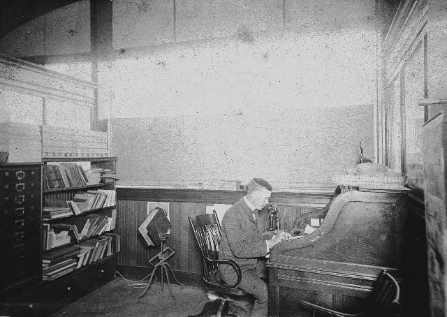 Bernard W. McKenzie seated at a desk in the Western Metal Supply office, 1893