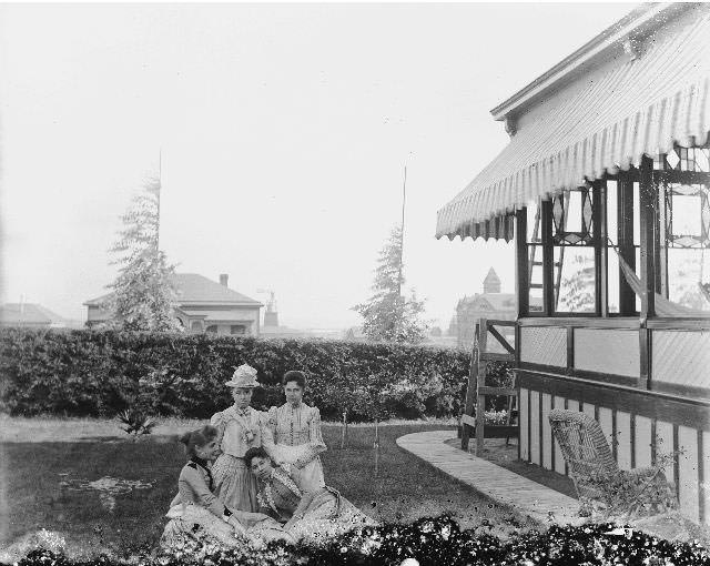 Four women in the back yard of a home, 1895