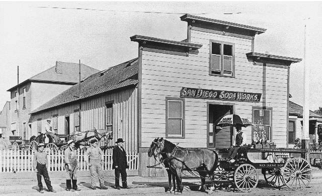 Four men standing in front of a San Diego Soda Works delivery wagon at the San Diego Soda Works, 1898