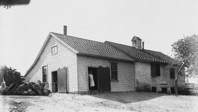 A man standing in the doorway of the Santa Ysabel Dairy, 1895