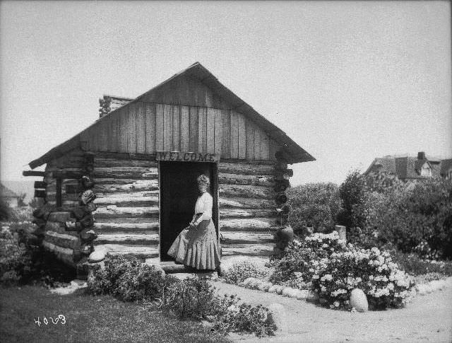 Miss Littlefield standing at the entrance to a cabin in Pacific Beach, 1899