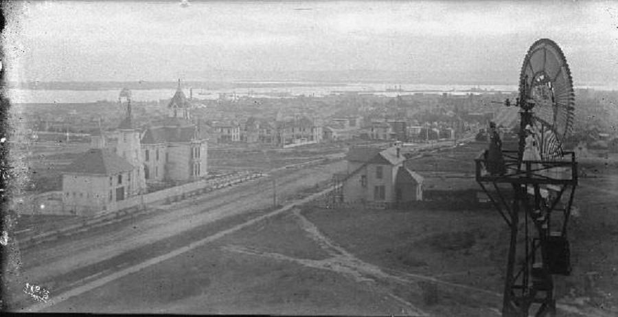 Two women standing at the top of windmill overlooking the residence of Matthew Sherman, 1895