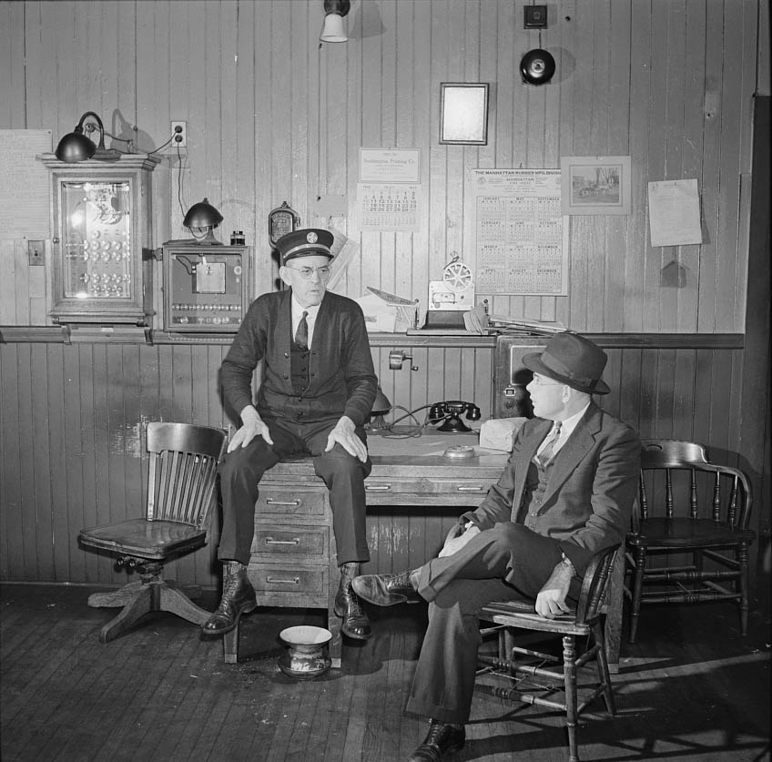 Thomas J. Murphy, chief of the fire department, and its only salaried member, chatting with one of the volunteers, 1942