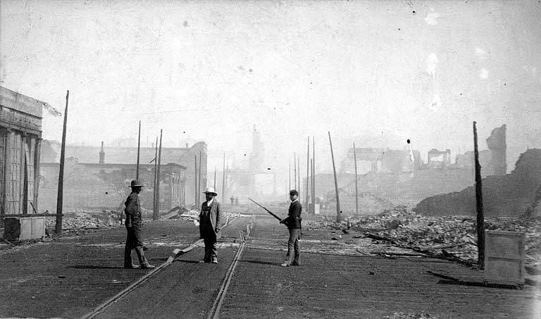 The ruins of buildings and a member of the Washington National Guard, 1889