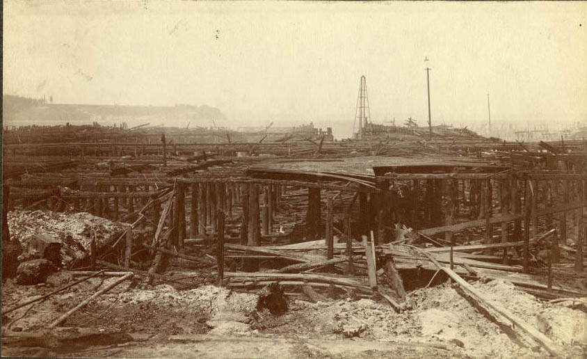 Ruins of Main St. wharves following fire, ca. June 1889