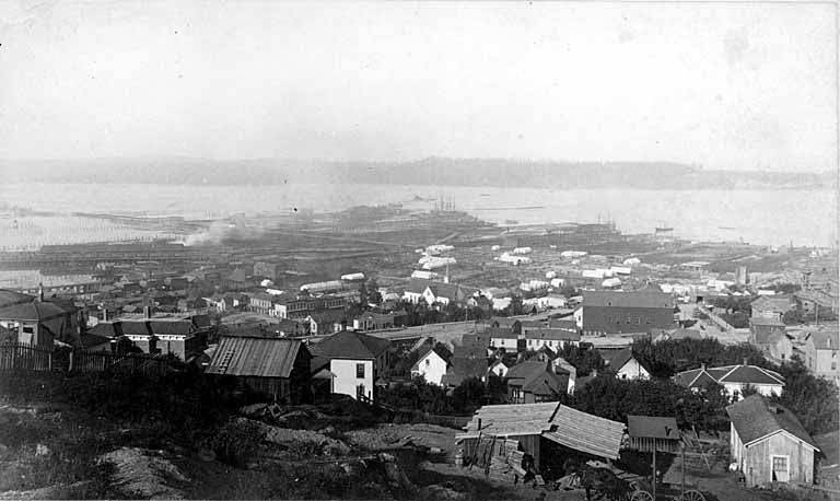 Looking southwest from a hill showing tents in the burned district and Elliott Bay, 1889