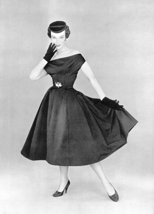 Victoria von Hagen in black satin party dress worn with small velvet cap by Christian Dior, 1953