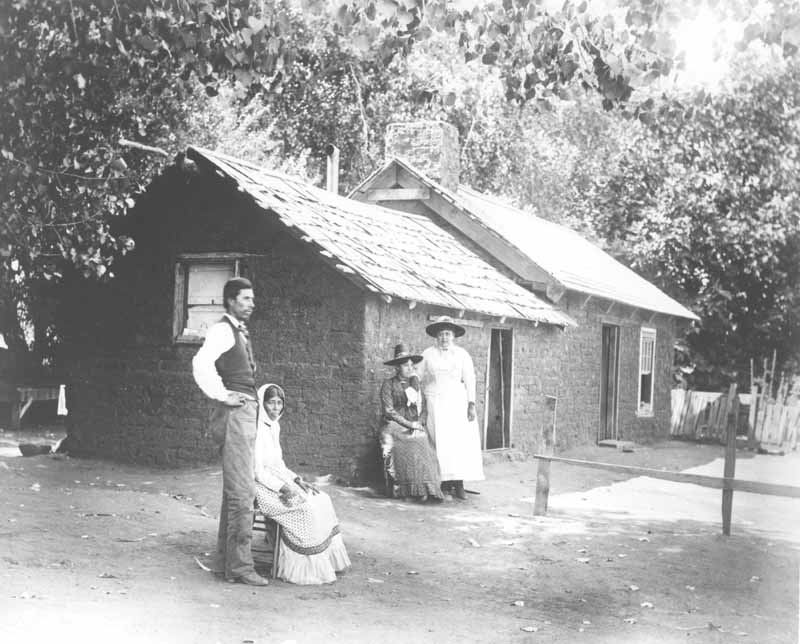 A Mexican family (Juan Levis and three women) in front of a house on Rancho El Tejon, 1880s