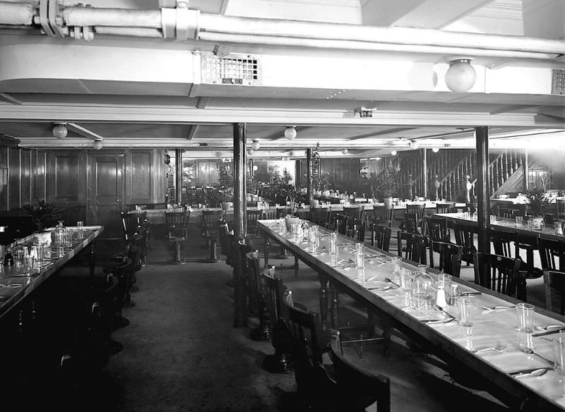 The forward section of Aquitania's 3rd Class Dining Saloon, on the Lower Deck (F Deck), looking across to the port side. Stairs up to the Main Deck are visible in the background on the right, May 1914