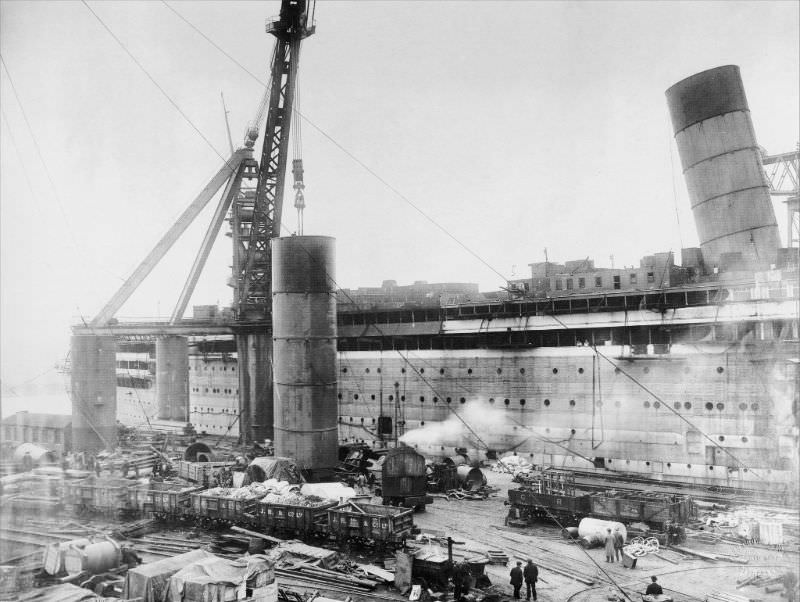 One of Aquitania's massive funnels is about to be hoisted onboard during the liner's fitting-out, circa 1913