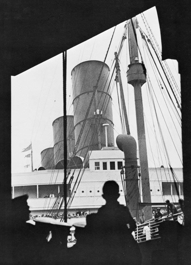 Aquitania about to sail to Europe from Pier 54, W. 12th St. A young New Yorker has been hoisted on to his dad's shoulders for a better view, circa 1934