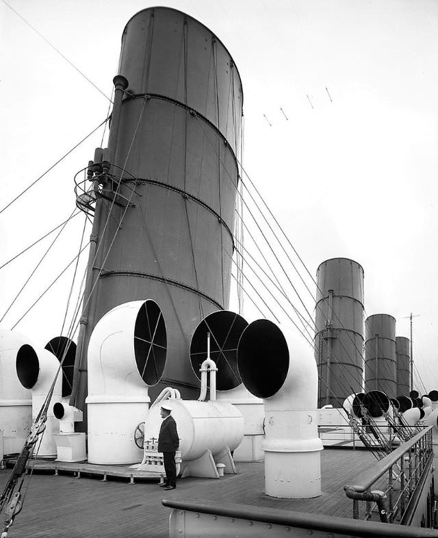 One of Aquitania's officers is dwarfed by the towering forward funnel and a collection of cowl ventilators.