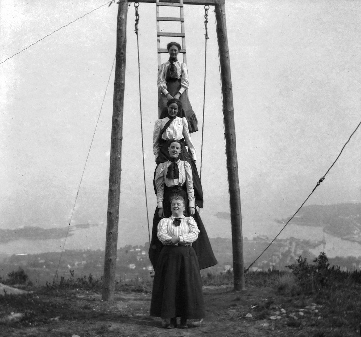 Friends and family of Theresa Babb perched on a ladder by the Summit House swing on August 17, 1898. Her sister Grace Parker is at the top of the ladder.