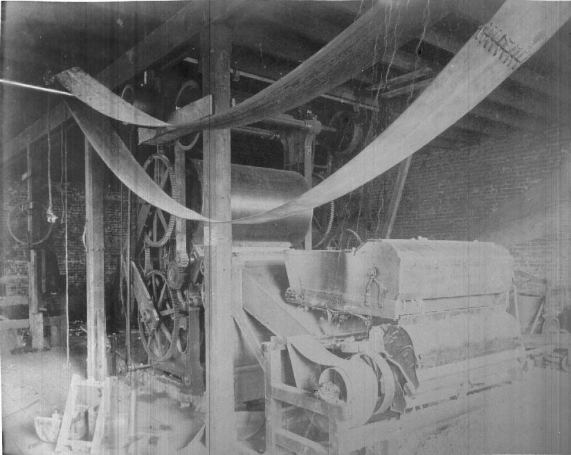 Cotton being placed on round bales and roller compressor, 1900