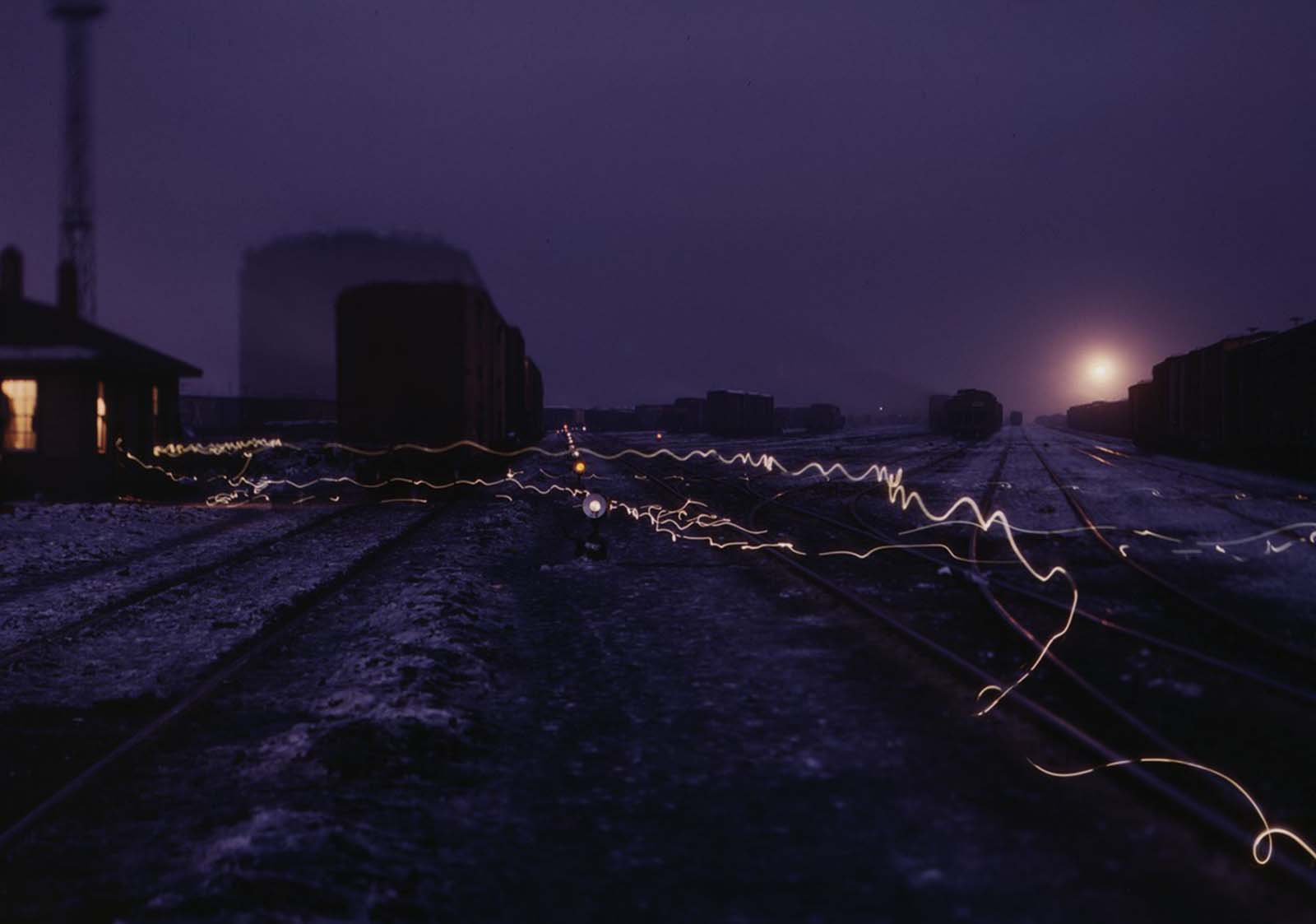 A long-exposure view of lantern lights in a departure yard in Chicago and North Western Railroad’s Proviso yard at twilight in December 1942.