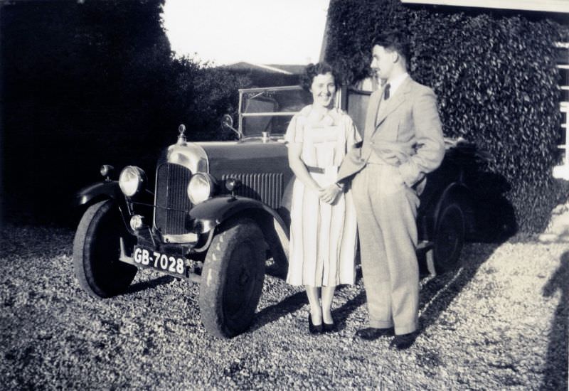 A cheerful lady in a light-colored dress and a fellow wearing a suit and tie posing with an English-built Citroën 7.5 H.P. Type C, circa 1936