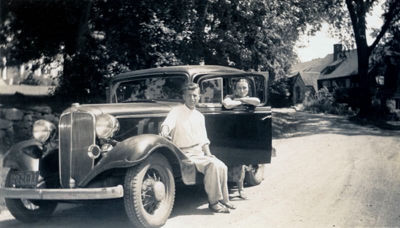 A leisurely clad couple posing with a 1933 Chevrolet Sedan on a sunny summer's day.