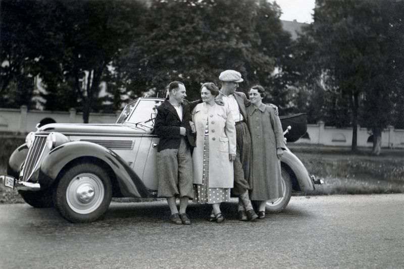 Two fashionable couples posing with an elegant two-tone Wanderer W 23 Cabriolet in summertime.
