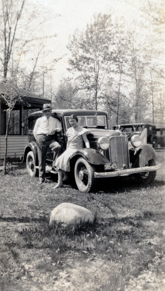 A middle-class couple posing with a 1932 DeSoto Six on a sunny spring day in the countryside.