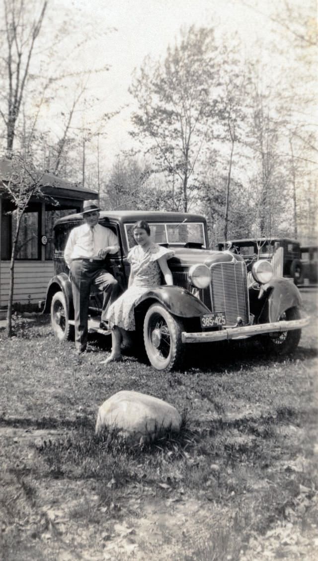A middle-class couple posing with a 1932 DeSoto Six on a sunny spring day in the countryside.