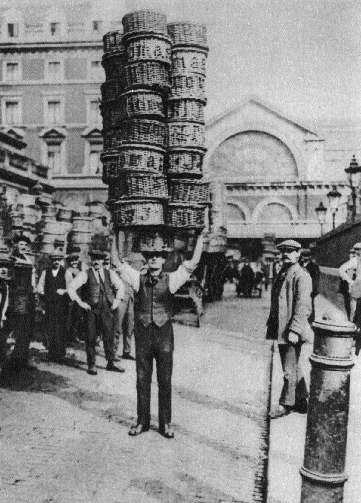 A porter carrying many baskets on his head, 1926.