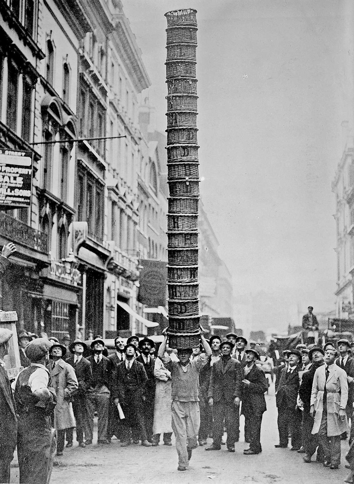E. W. White, porter, carrying twenty baskets stacked to King Street, Covent Garden, 1931.