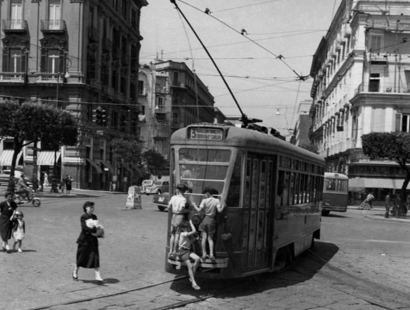 Children hanging on a tram.