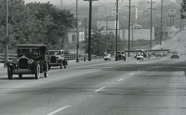 Antique cars and an historic airplane driving on the road, going to the 1982 Courthouse Day hosted in Nashville, Tennessee.