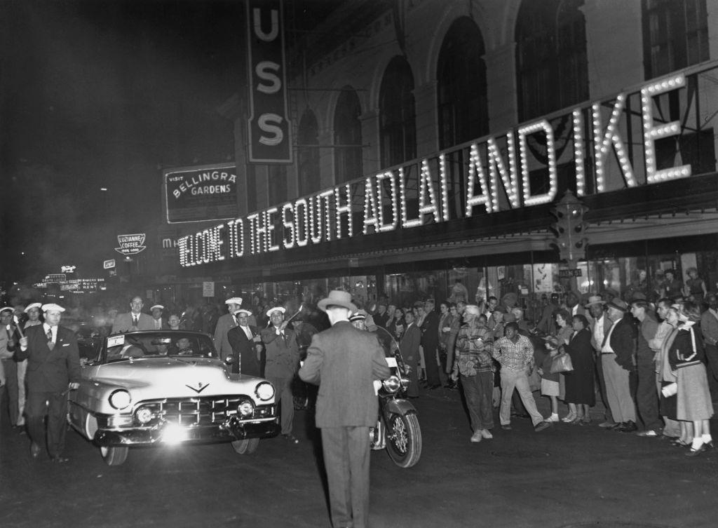 The car in which Governor Adlai Stevenson drove into New Orleans from the airport after his arrival is sown passing a huge electric sign which blazes, 1952.