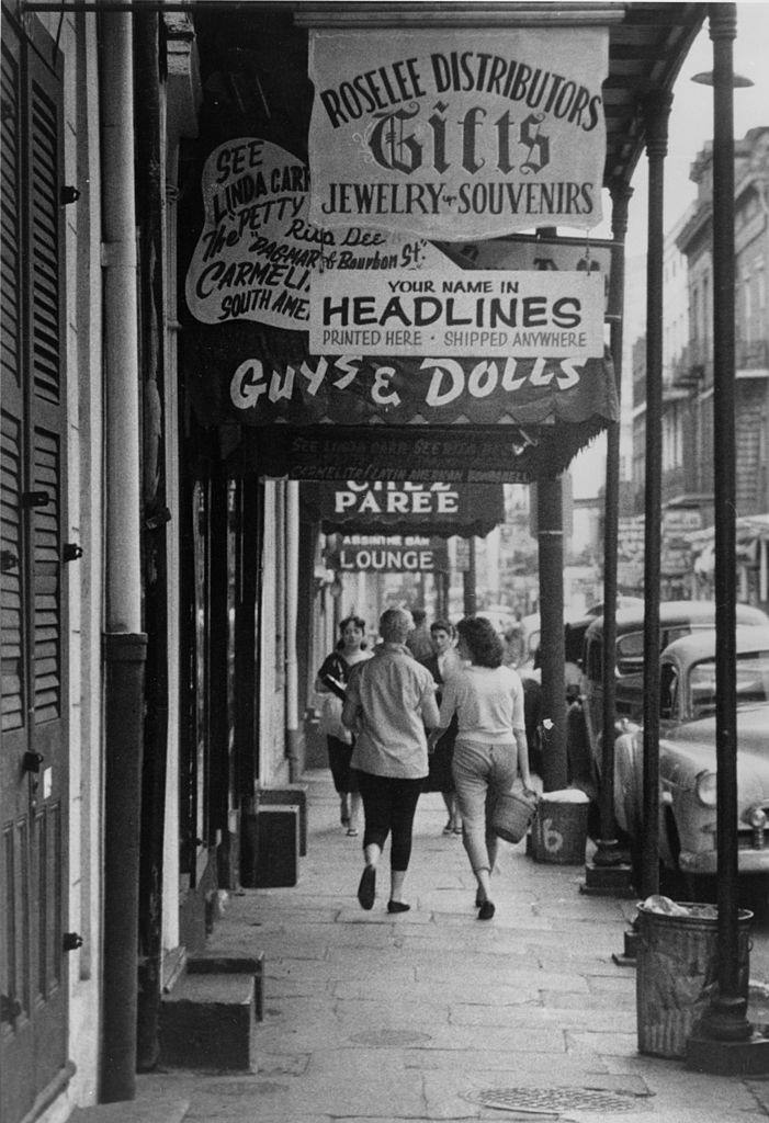 Two women walking along a pavement on Bourbon Street, New Orleans, 1955