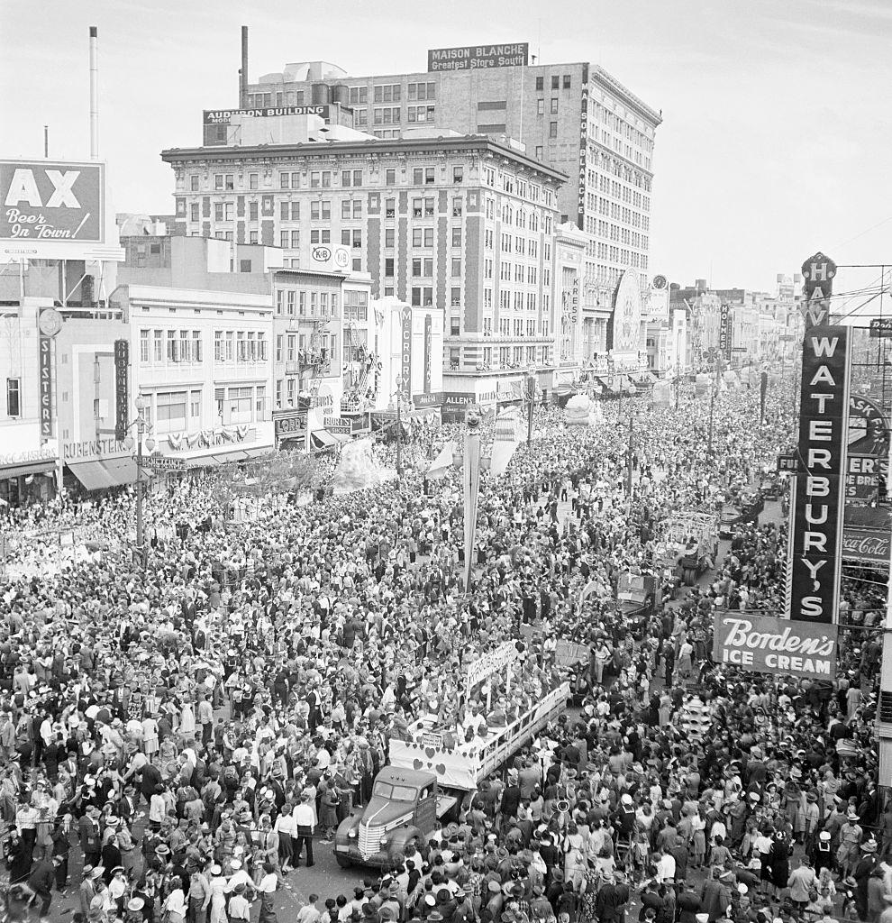 Crowds throng a major street in New Orleans for a Mardi Gras parade, New Orleans, 1950