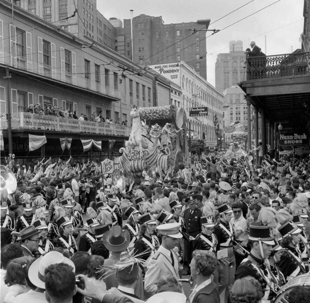 A float at the New Orleans Mardi Gras represents the biblical theme of Moses parting the Red Sea, while a marching band leads the procession.