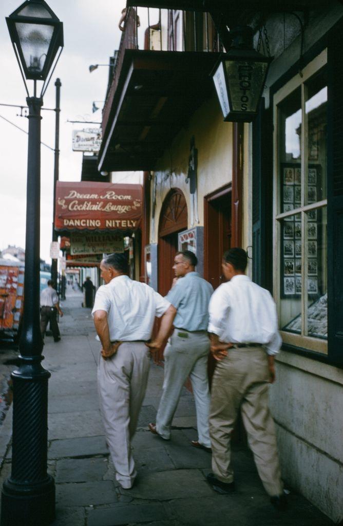 A view as men walk down bourbon street toward the Dream Room Cocktail Bar n New Orleans, 1957.