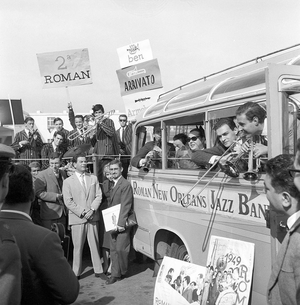The Roman New Orleans Jazz Band on a truck adorned with welcoming signs receiving the American musician Louis Armstrong arrived at the Ciampino Airport.