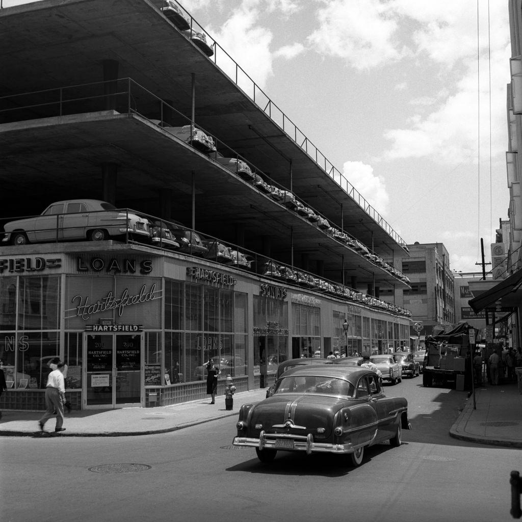 Parking lot three story building architecture car on street pedestrian, New Orleans, 1950s