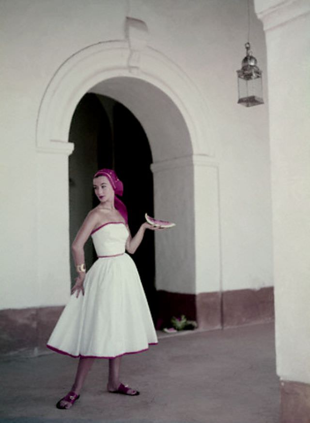 Ruth Neuman Derujinsky wearing a strapless white cotton dress with a matching handkerchief by Pat Premo and Bernardo sandals, 1953