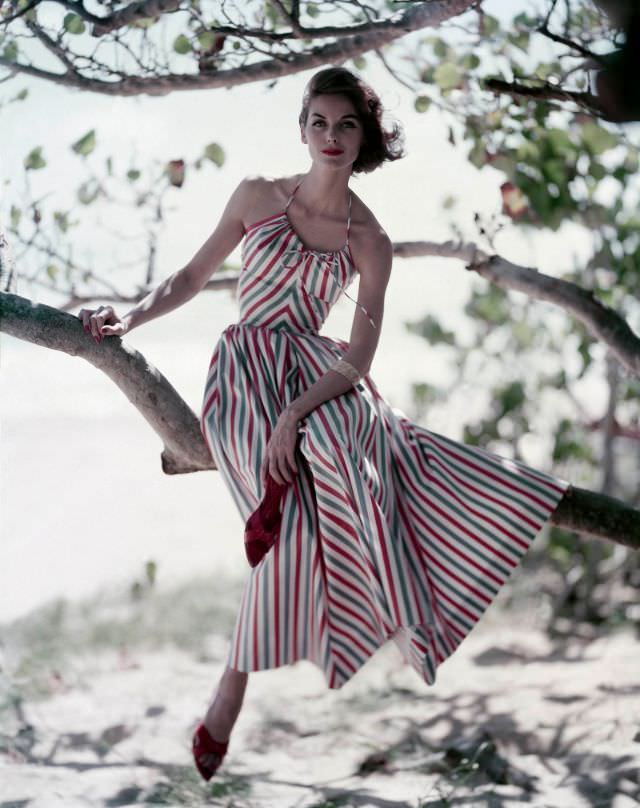Anne St. Marie wearing a red, white and blue stripe dress with a halter top and a full, ankle-length skirt, with red stiletto mules, by Hope Skillman, 1957